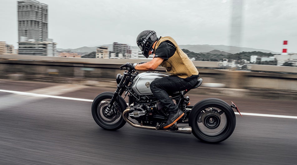 Custom & Heritage motorcycle with Öhlins suspension riding on urban street.